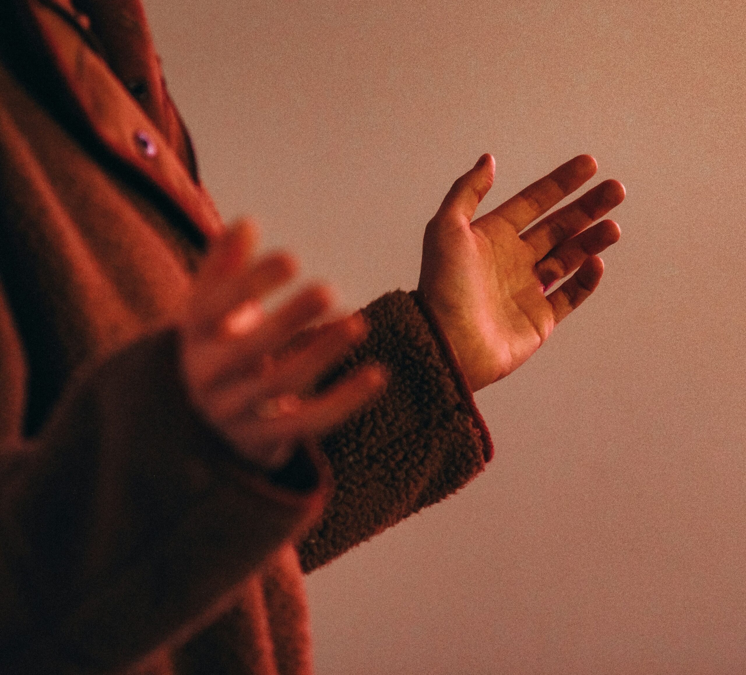 Person making a gesture with both hands in a somatic therapy session.